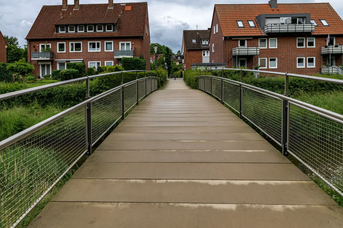 Ein Fußweg verbindet mehrere Wohnhäuser in einer ruhigen Siedlung