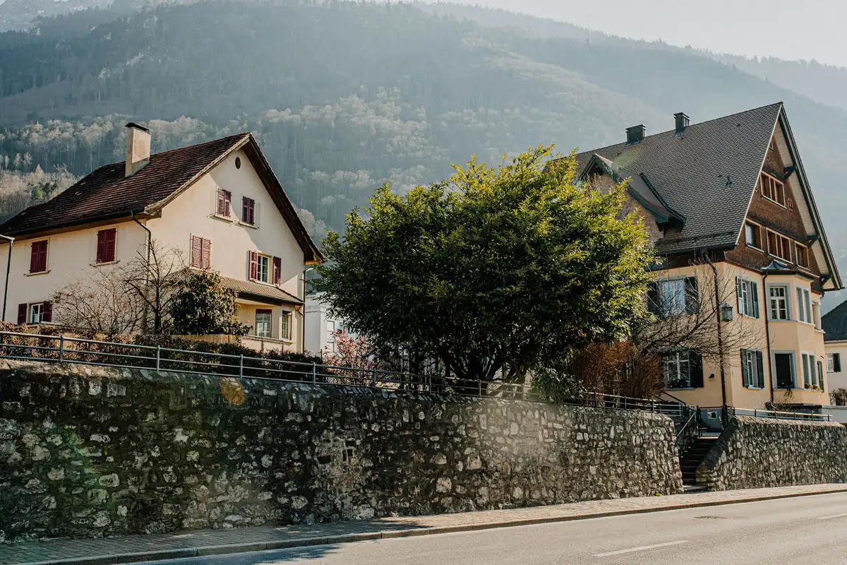 Wohnhäuser stehen an einer ansteigenden Straße mit Hanglage