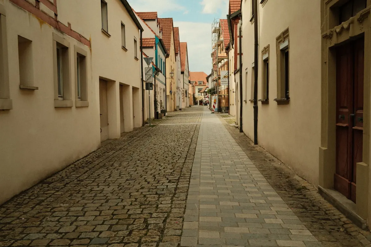 Eine schmale gepflasterte Gasse verläuft zwischen Wohnhäusern