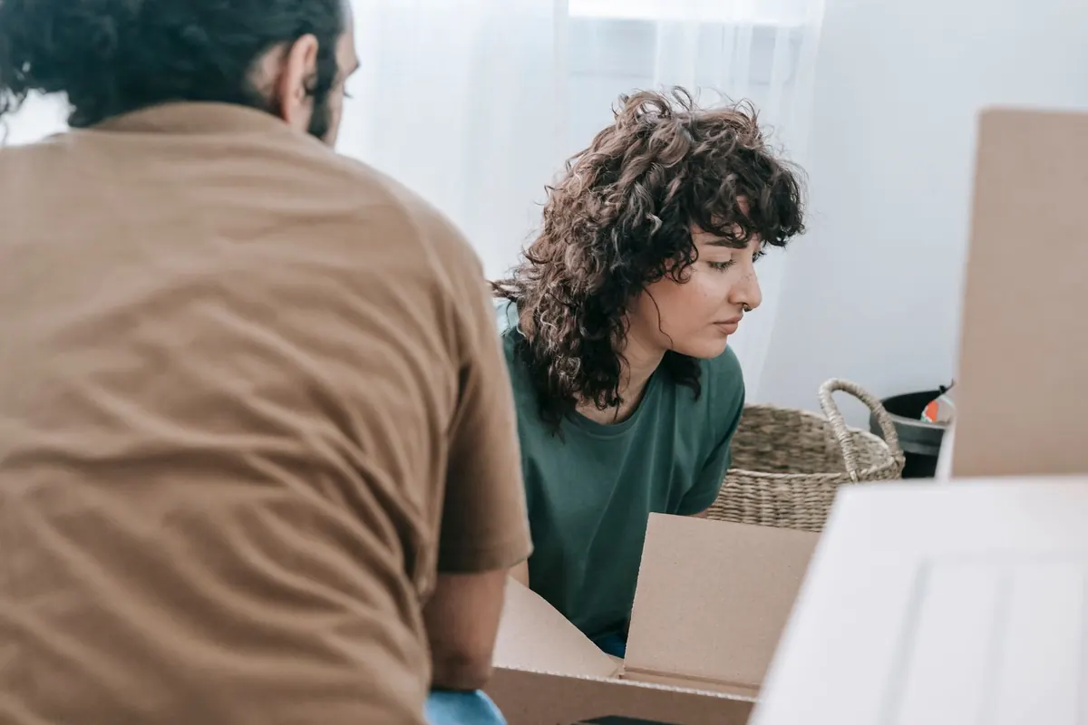 Zwei Umzugshelfer stimmen sich zwischen gepackten Kartons ab