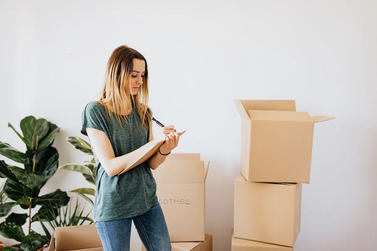 Eine Frau bereitet mehrere Kartons in einer Wohnung vor